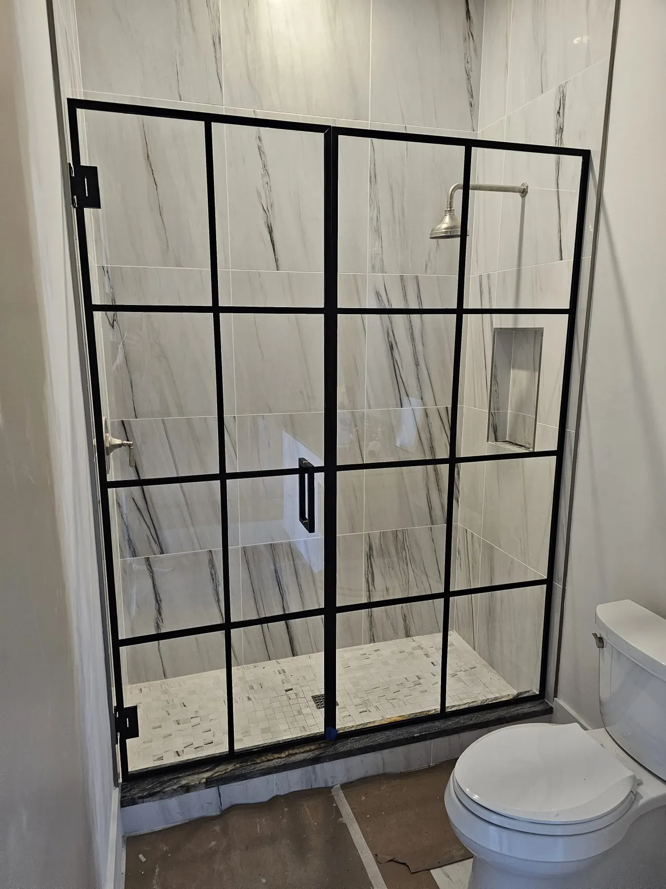 after framed swing shower glass with black hardware in Southwest Florida