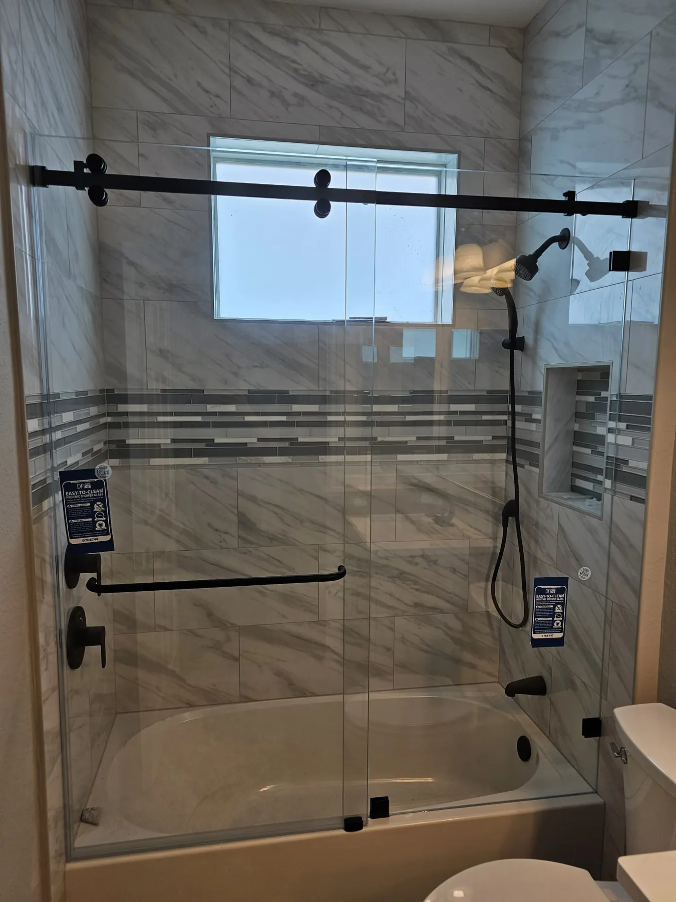 after frameless sliding shower glass with black hardware in Southwest Florida