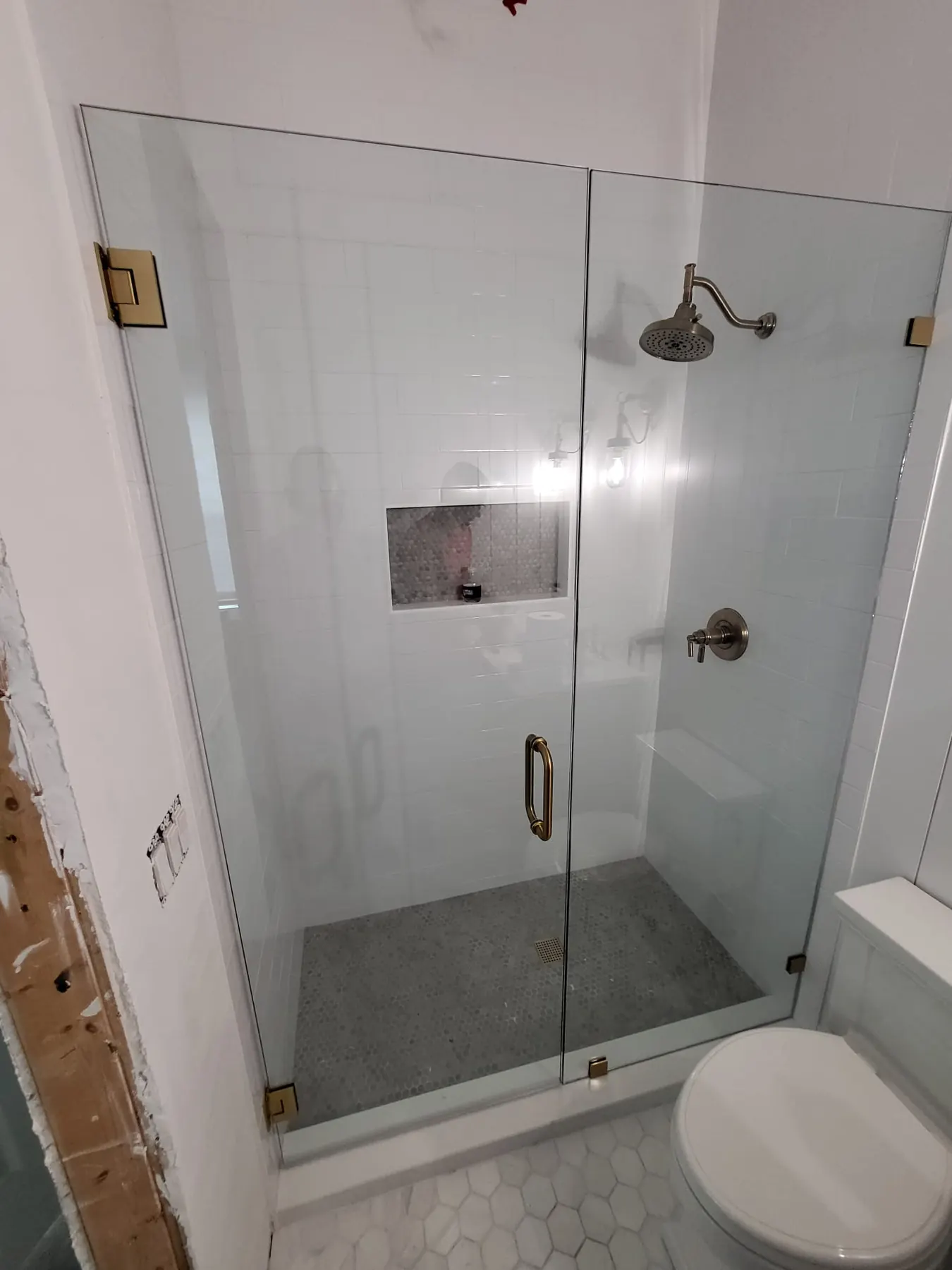 after frameless swing shower glass with brushed gold hardware in Southwest Florida