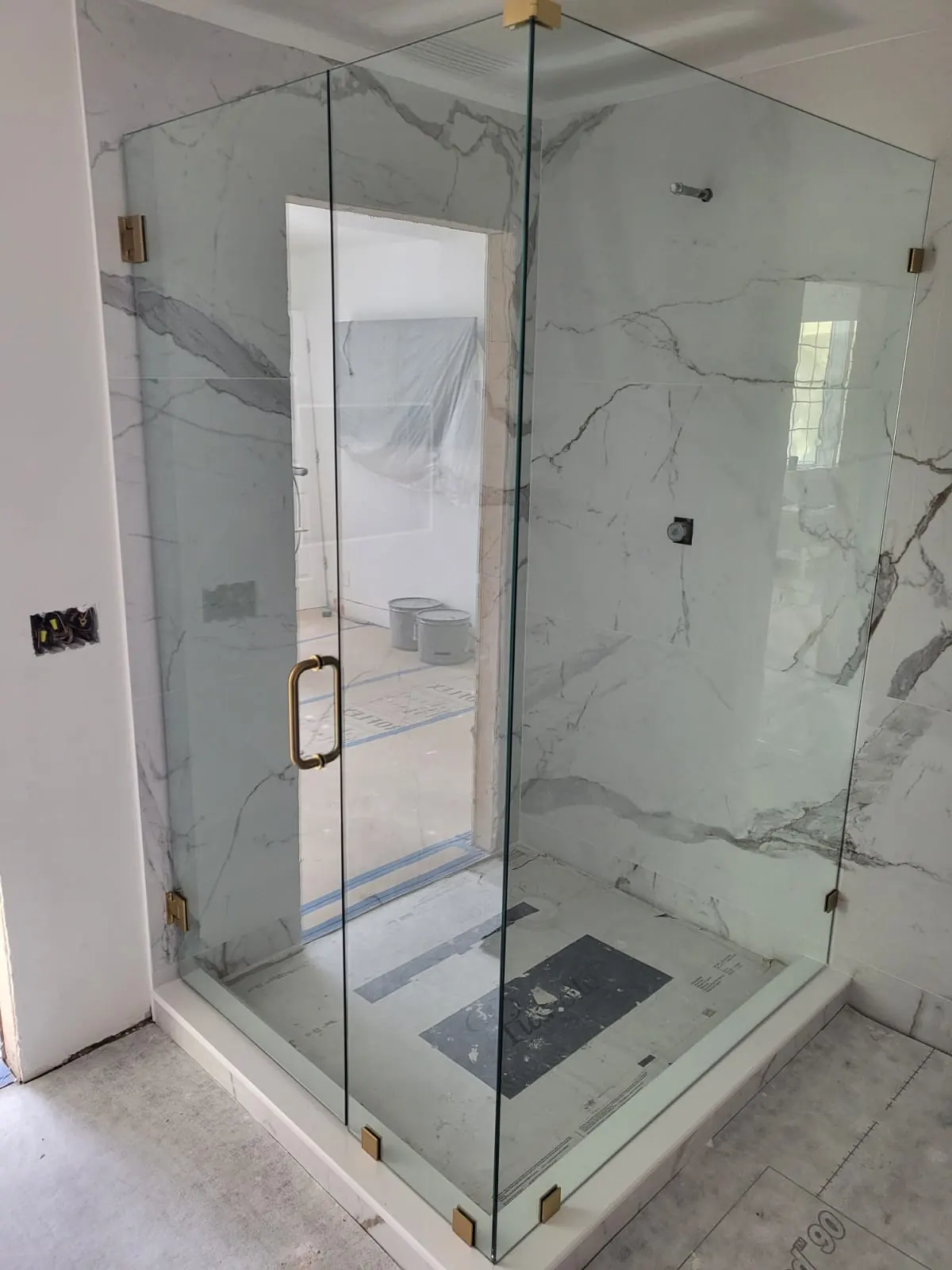after frameless swing shower glass with brushed gold hardware in Southwest Florida