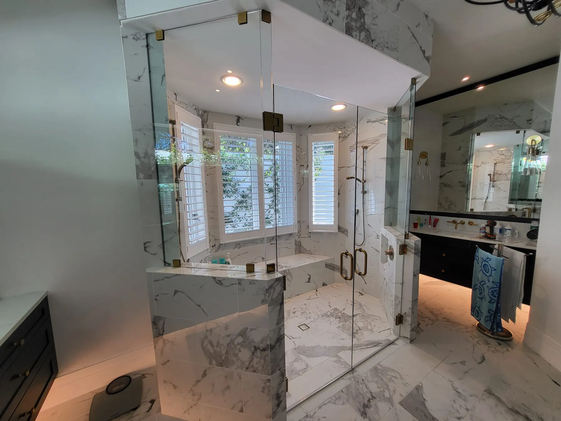 after frameless swing shower glass with brushed gold hardware in Southwest Florida