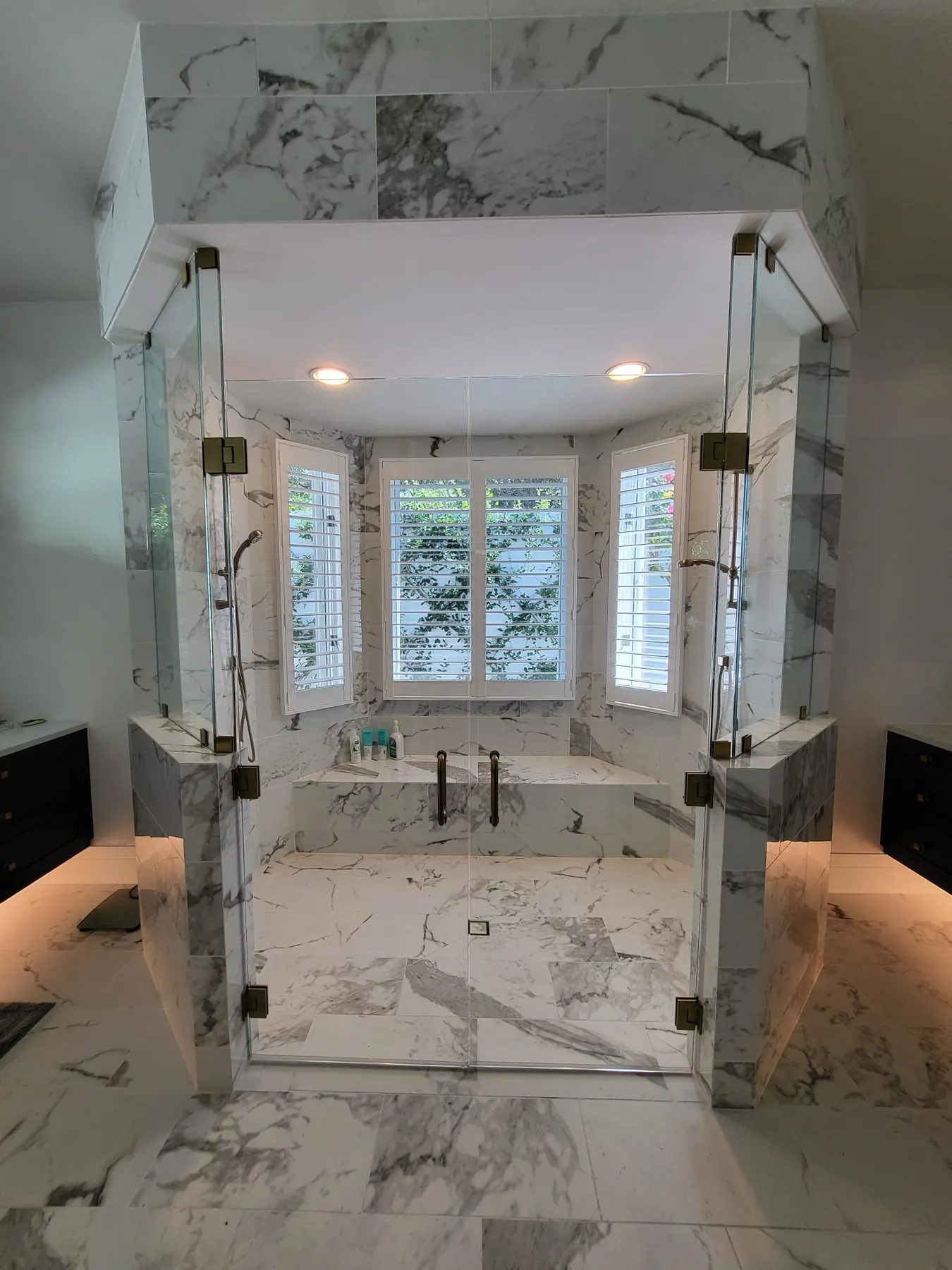 after frameless swing shower glass with brushed gold hardware in Southwest Florida