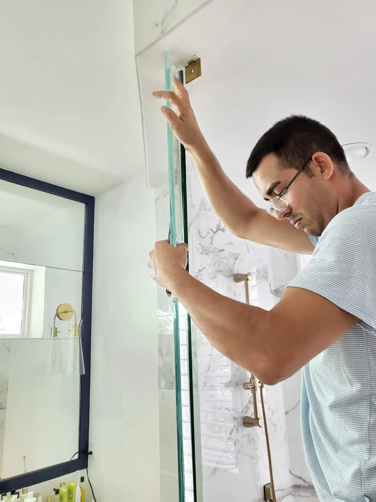 before frameless swing shower glass with brushed gold hardware in Southwest Florida
