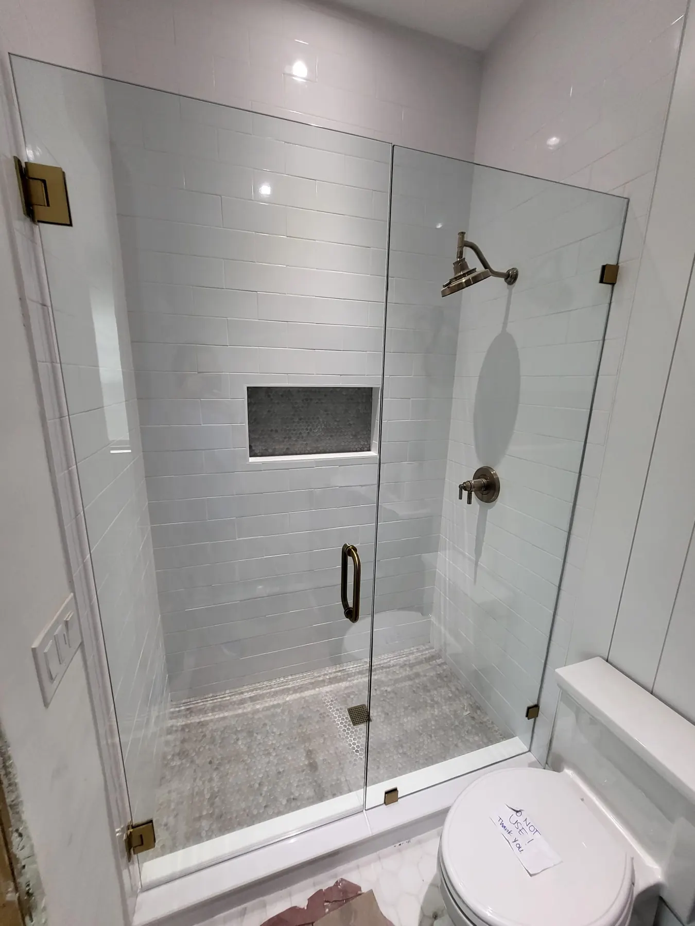 after frameless swing shower glass with brushed gold hardware in Southwest Florida