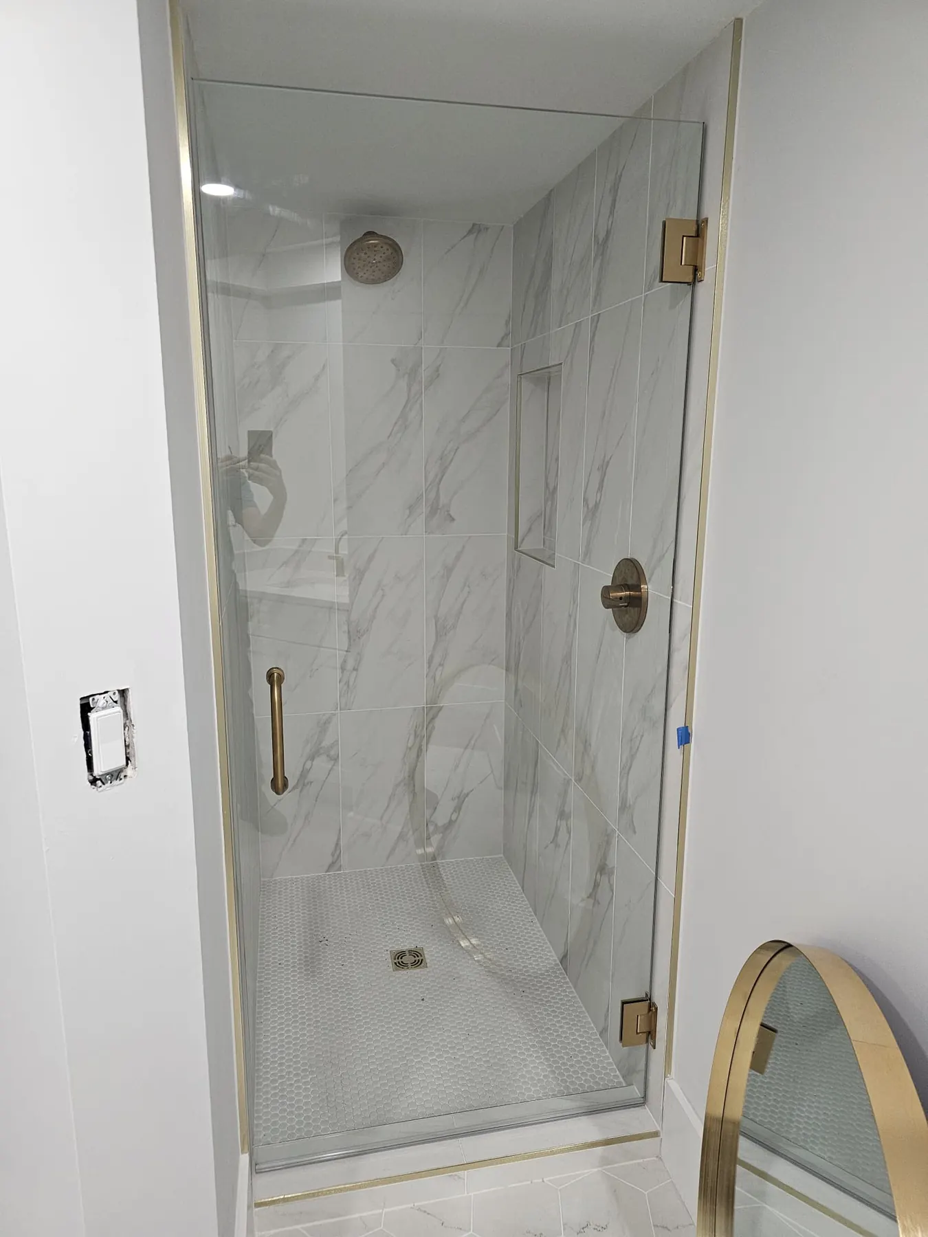 after frameless swing shower glass with brushed gold hardware in Southwest Florida