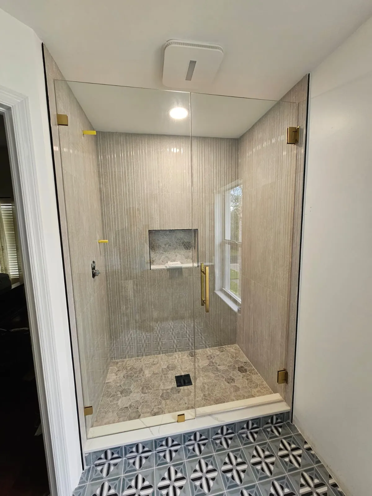 after frameless swing shower glass with brushed gold hardware in Southwest Florida