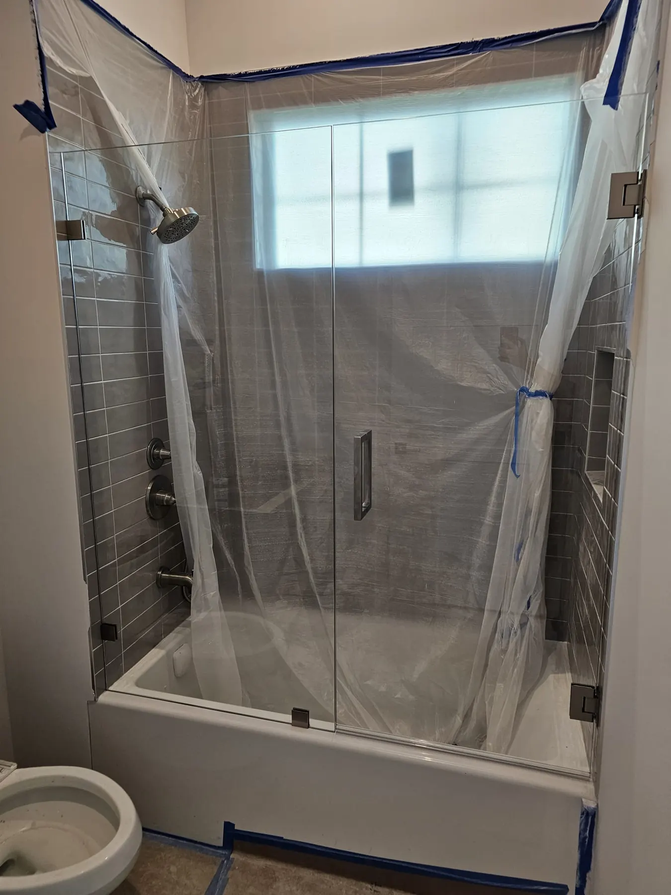 after frameless swing shower glass with brushed nickel hardware in Southwest Florida