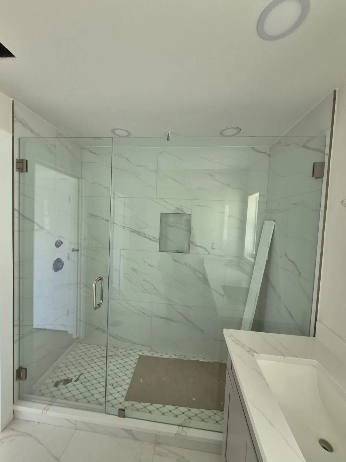 after frameless swing shower glass with brushed nickel hardware in Southwest Florida
