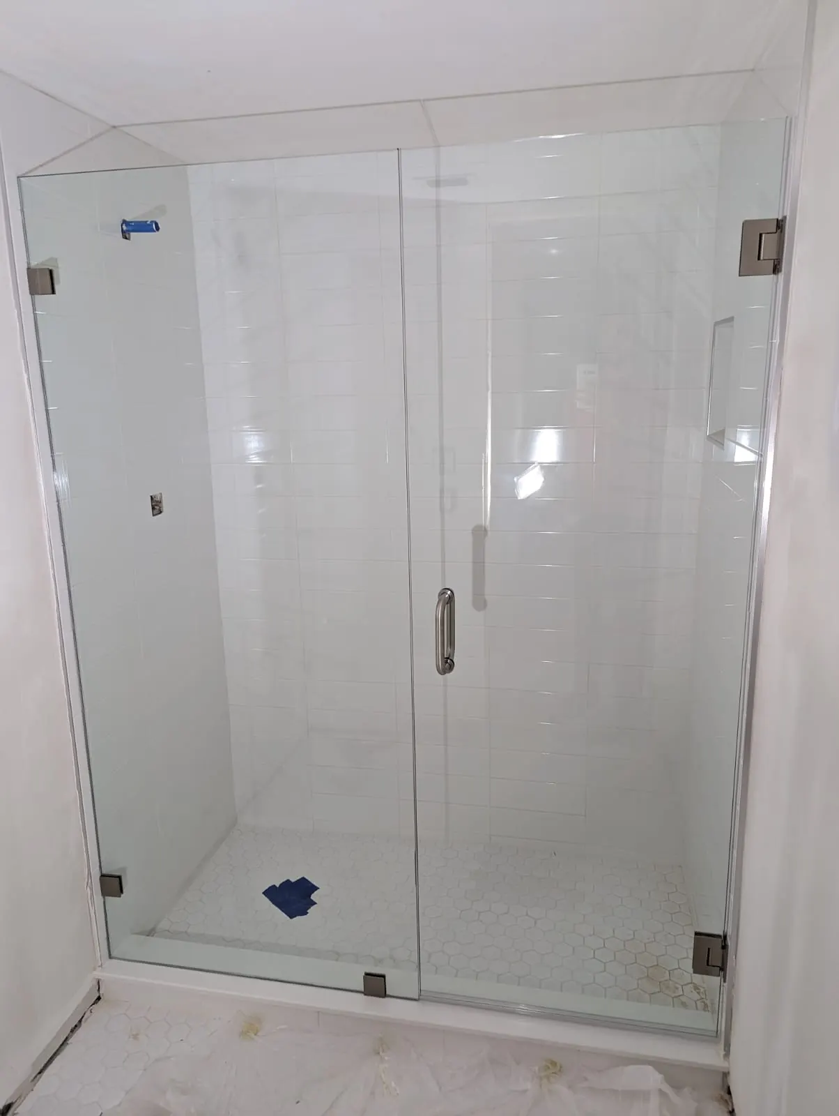 after frameless swing shower glass with brushed nickel hardware in Southwest Florida