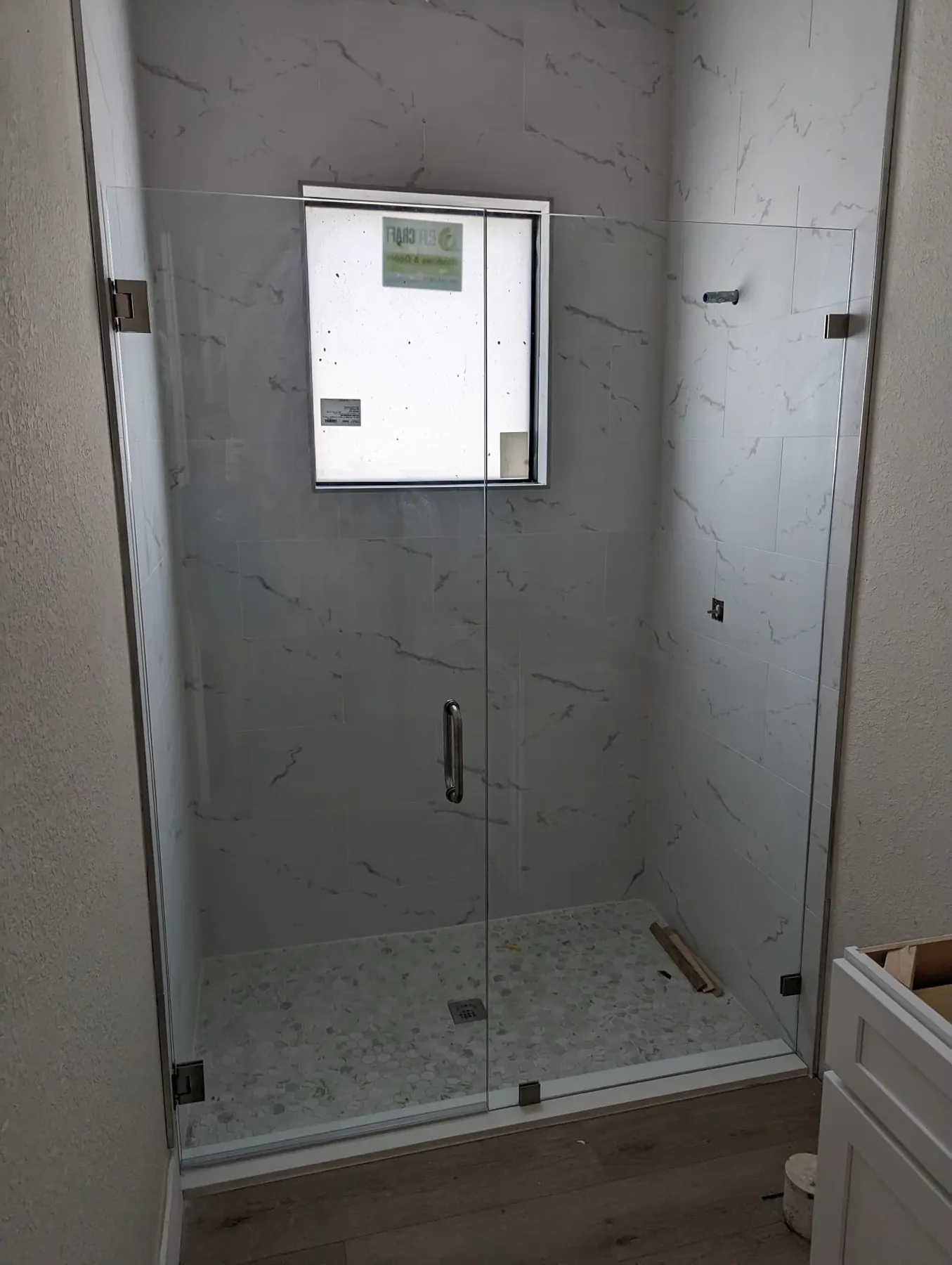 after frameless swing shower glass with brushed nickel hardware in Southwest Florida
