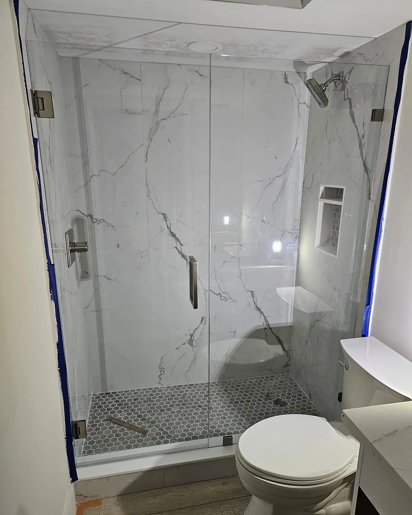 after frameless swing shower glass with brushed nickel hardware in Southwest Florida