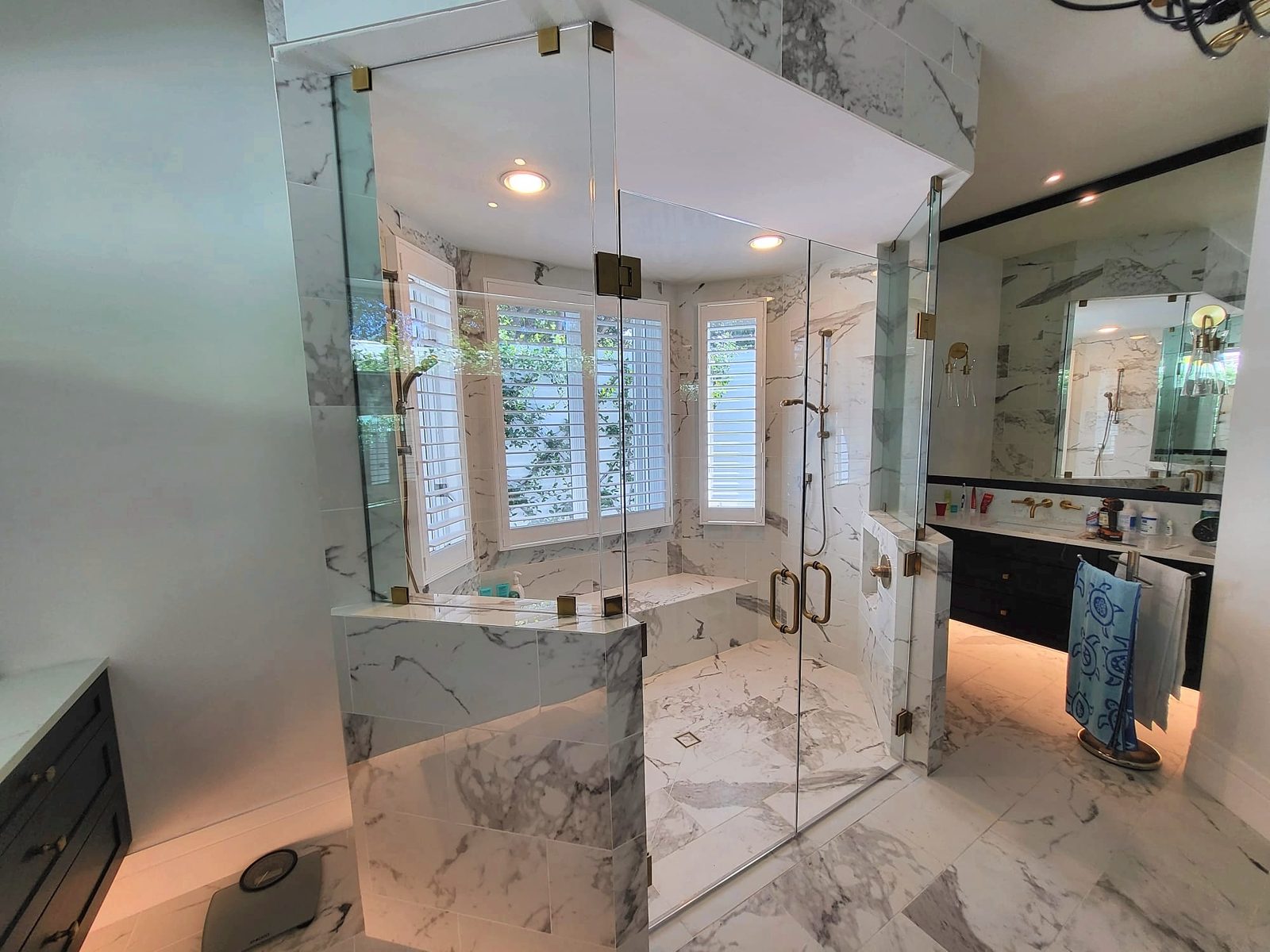 frameless shower glass enclosure with brass hardware installed in a Southwest Florida bathroom remodel
