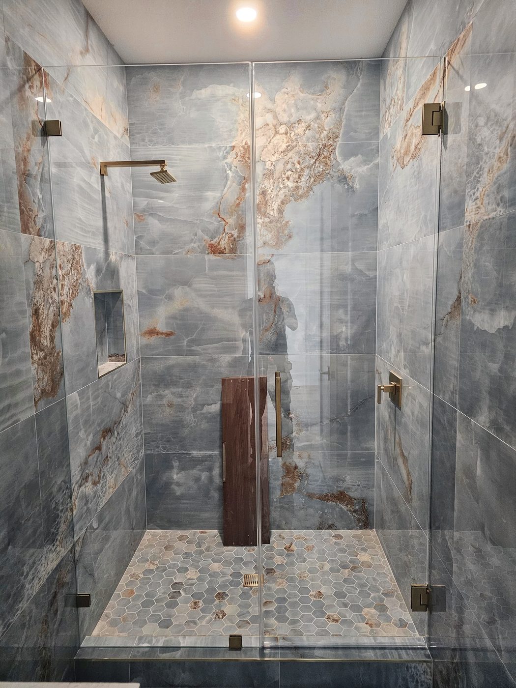 statement tile shower with frameless glass installed for a remodeler project in Southwest Florida